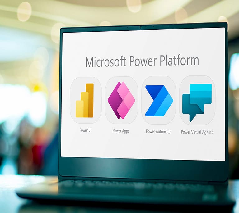 Microsoft Power Platform applications including Power BI, Power Apps and Power Automate displayed on a laptop representing connected business systems and integration.