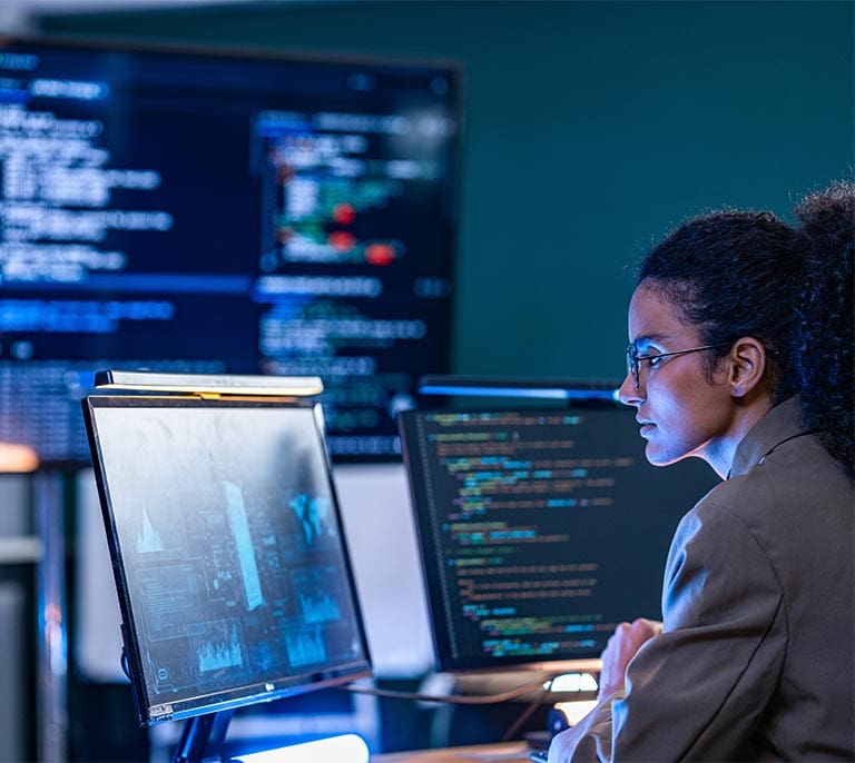 Software developer working on scalable application architecture and enterprise software development across multiple screens.
