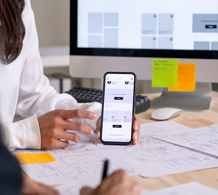 Mobile website interface and wireframes being reviewed as part of a user experience optimisation project.