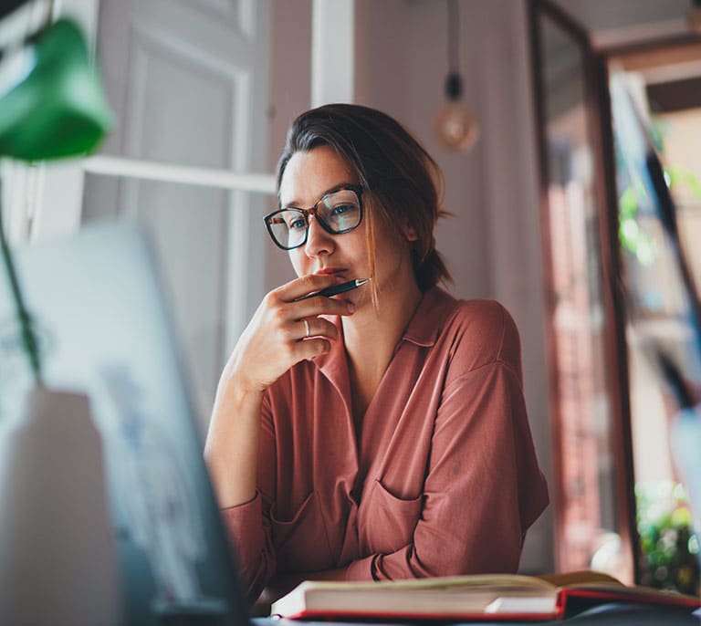 Professional copywriter reviewing and creating website content on a computer for a business website.